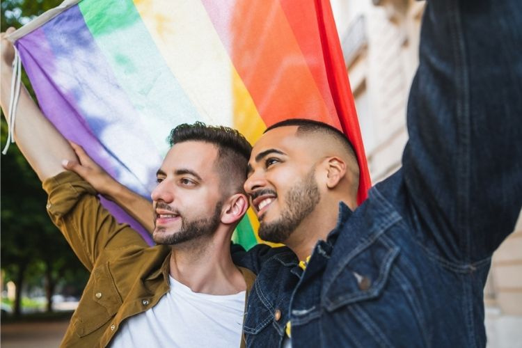 gay couple celebrating pride with pride flag