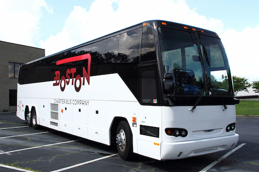 a plain white charter bus with a "Boston Charter Bus Company" logo